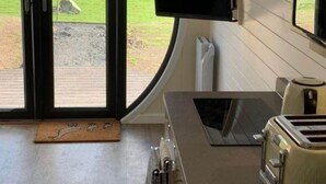 Een moderne keuken met een groot raam, een flatscreen televisie en een broodrooster.