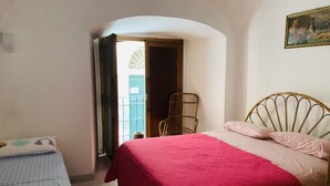 Une chambre à coucher avec un lit, une chaise et une fenêtre.