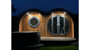 Stunning circular building with a large round window and outdoor seating area.