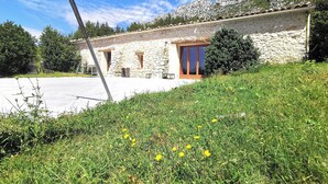 A stone building with a tiled roof, a wooden door, and a window with a curtain. - Very pretty, bright, south-facing sheepfold on an organic farm in the Verdon.  (Var)