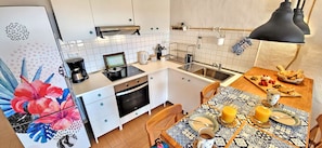 Een koelkast, een oven, een kookplaat, een koffiezetapparaat/waterkoker