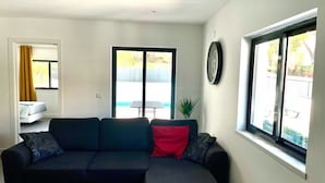 A modern living room with a sectional sofa, a small table, and a potted plant.