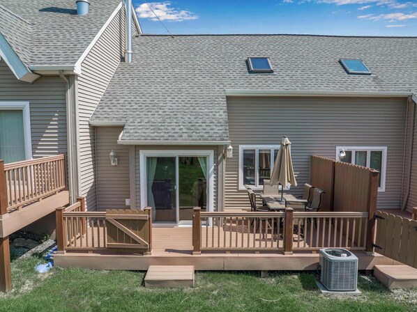 A residential property with a deck, a sliding glass door, and a small patio area. - 3-Bed Family Townhouse with Scenic Views & Patio (Ellicottville)