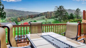 Terraza con mesa y sillas con vista a un campo de golf.
