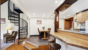 Una cocina moderna con encimera de madera, estufa integrada y zona de comedor con mesa y sillas.