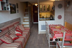 Ein gemütlicher Wohnbereich mit Sofa, Esstisch und Küchenzeile.