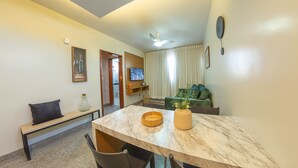 Una sala moderna con una mesa de comedor de mármol, un banco y un sofá verde.