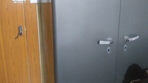 Una habitación con un armario de madera y un armario de metal gris.