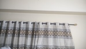 Un baño con cortina de ducha estampada con un diseño geométrico.