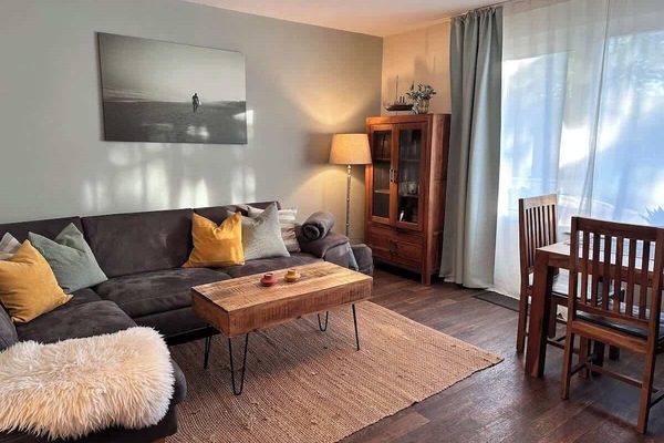 Gemütliches Ecksofa mit Kissen und Decken im Wohnzimmer.