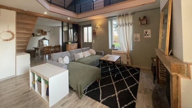 A spacious loft-style living area with a high ceiling, a mezzanine level, and a cozy seating area with a sofa and a coffee table. - Juliette's garden (Gournay-le-Guérin)