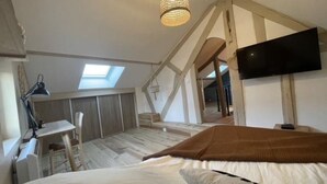 A bedroom with a bed, a desk, a chair, a TV, and a skylight. - Juliette's garden (Gournay-le-Guérin)