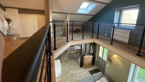 A spacious loft with a mezzanine level, a skylight, and a view of the outdoors. - Juliette's garden (Gournay-le-Guérin)