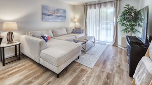 Een moderne woonkamer met een bank, salontafel en een flatscreen televisie.