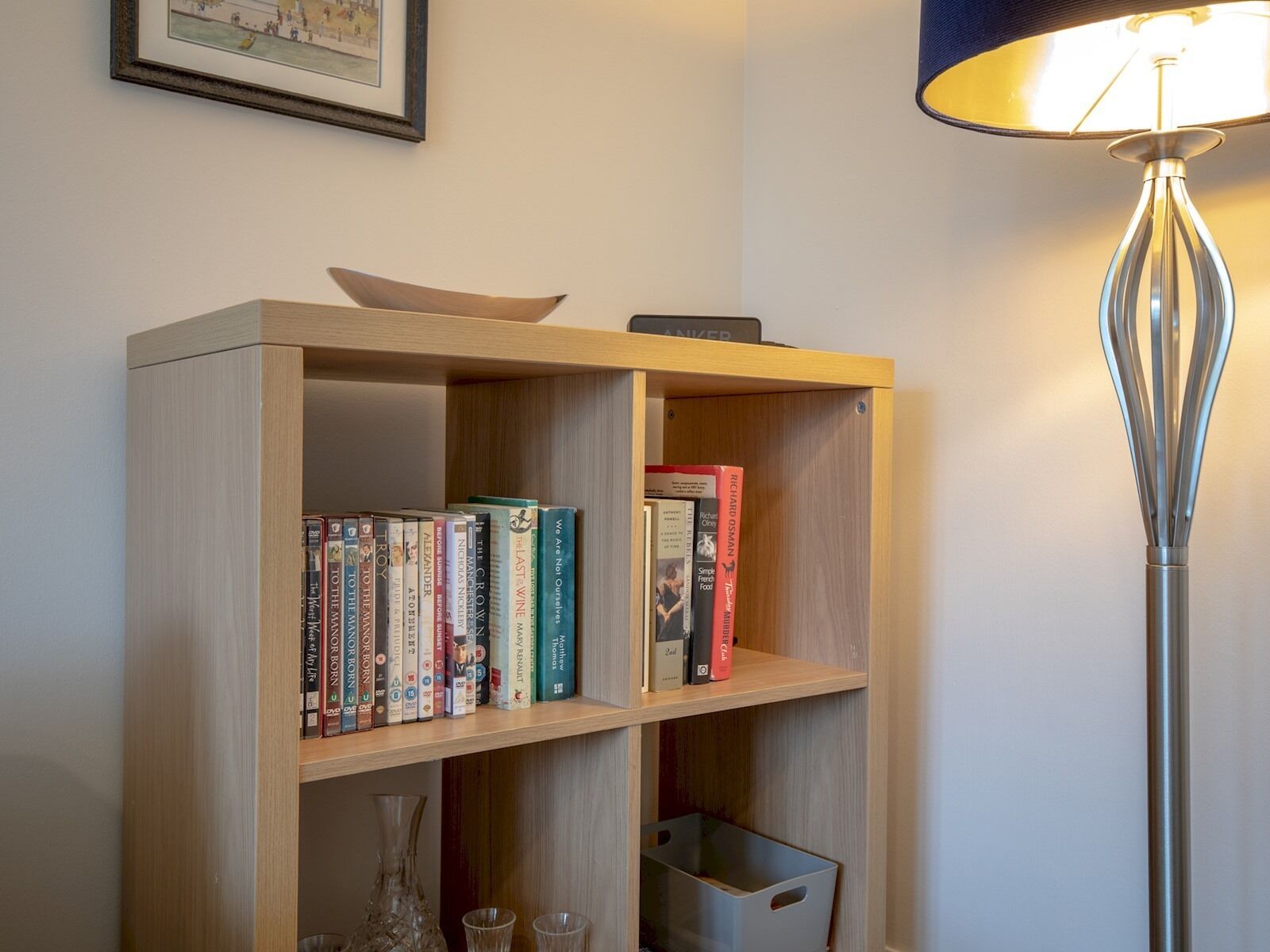 A bookshelf with books and a lamp.