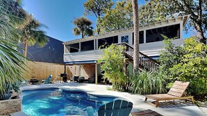A backyard with a swimming pool, a covered patio, and outdoor furniture. - The Fort | Private Pool, Fire Pit Arcade Games (Tybee Island)