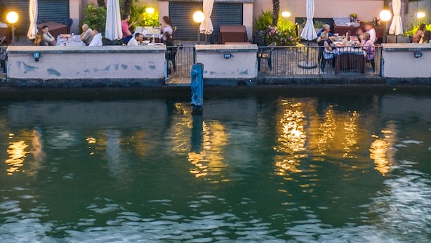 Een gebouw aan het water met terras en een overdekte patio.