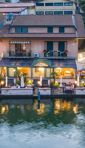 Un bâtiment situé au bord de l’eau, doté d’une terrasse extérieure et d’un patio couvert.