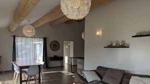 A modern living room with a wooden coffee table, a sofa, and a dining area with a table and chairs.