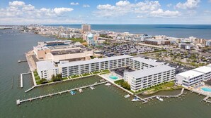 A coastal cityscape with a marina, modern buildings, and a clear view of the ocean. - Thunder Island Condo - Beautiful 2 BR 2 BA Next to Convention Center (Ocean City)