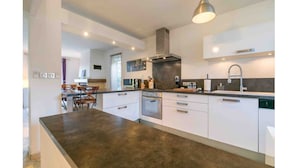 Una cucina moderna con isola centrale, forno integrato ed elettrodomestici in acciaio inossidabile.