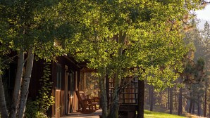 Eine Holzdiele mit Veranda, Schaukelstühlen und Bücherregal.