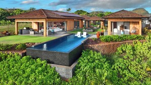 A modern resort with a swimming pool, outdoor seating areas, and lush landscaping. - Hale Kupanaha: Opulent New Villa + Pool/Spa/Views (Koloa)