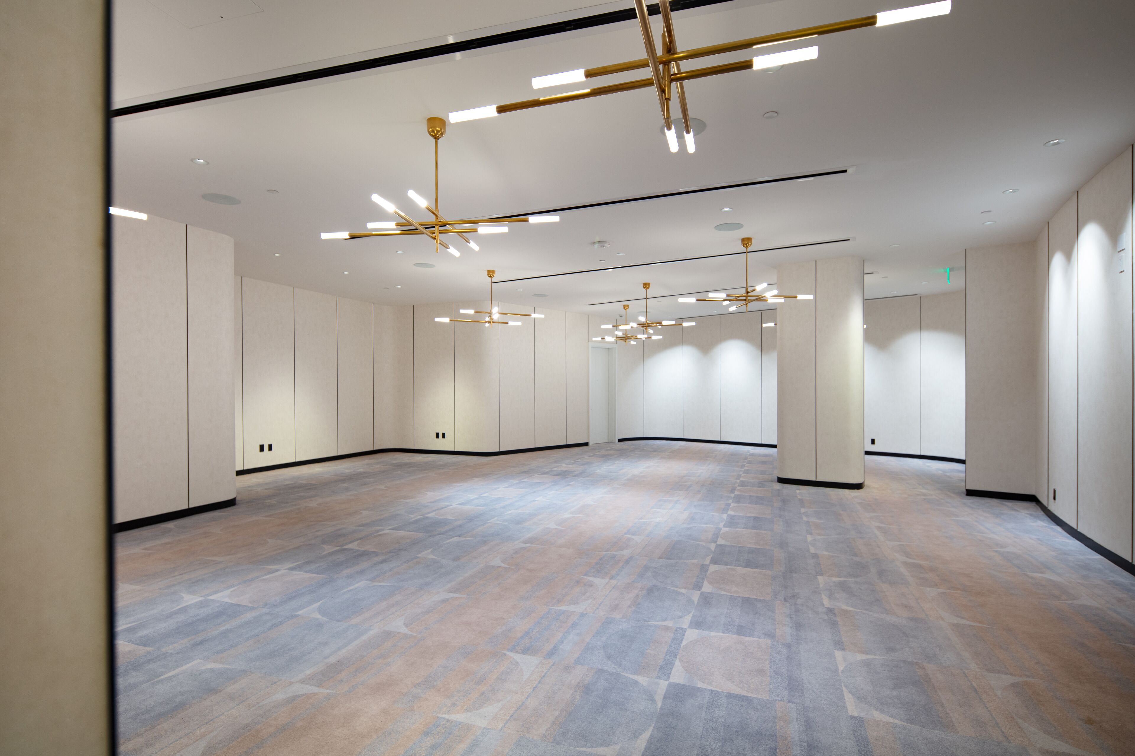 En rummelig hotellobby med et moderne design, stor åben område, høje lofter og moderne lysarmaturer.