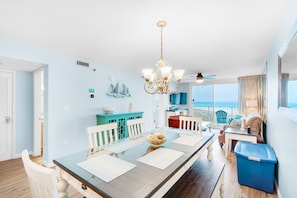 Enjoy meals with a view of the ocean from this dining area, featuring a long table for four and nautical decor.