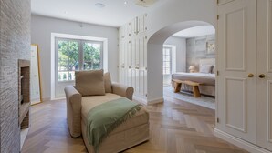 A spacious room with a large window, a fireplace, a sofa, and a bed. - Portuguese mansion close to marina, golf and beach. (Quarteira)