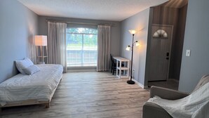A modern hotel room with a large bed, a sofa, a desk, and a view of the outdoors. - 4-bedroom oasis  in Navarre with enclosed heated  pool (Navarre)