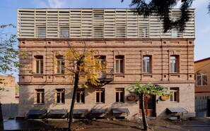 Un bâtiment en briques doté de nombreuses fenêtres et d’une enseigne indiquant « HÔTEL MACHOLO ».