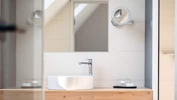 Une salle de bain moderne avec un meuble-lavabo en bois, un grand miroir et un lavabo blanc.