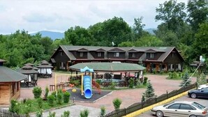 Una cabaña con varias casetas, un parque infantil y una zona de estacionamiento.