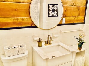 Een bad/douchecombinatie, handdoeken, zeep, toiletpapier