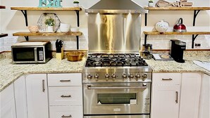Une cuisine moderne équipée d’une cuisinière, d’un four, d’un four à micro-ondes et de divers ustensiles de cuisine.