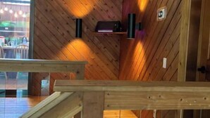 A wooden interior with a high ceiling, ductwork, and a glass partition. - Luxury Cabin with Indoor Heated SaltWater Pool! (Old Forge)