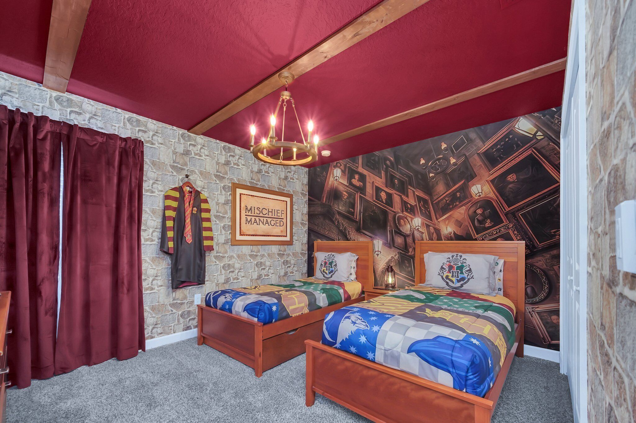 Une chambre à coucher avec deux lits en bois, un mur en pierre, un plafond rouge et une fresque représentant une pièce remplie de divers objets.