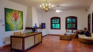 Un salon comprenant un coin repas, un téléviseur et un grand tableau accroché au mur.