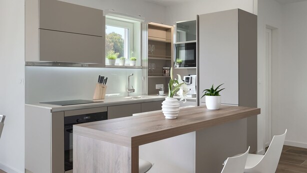 A modern kitchen with a central island, built-in appliances, and a view of the outdoors.