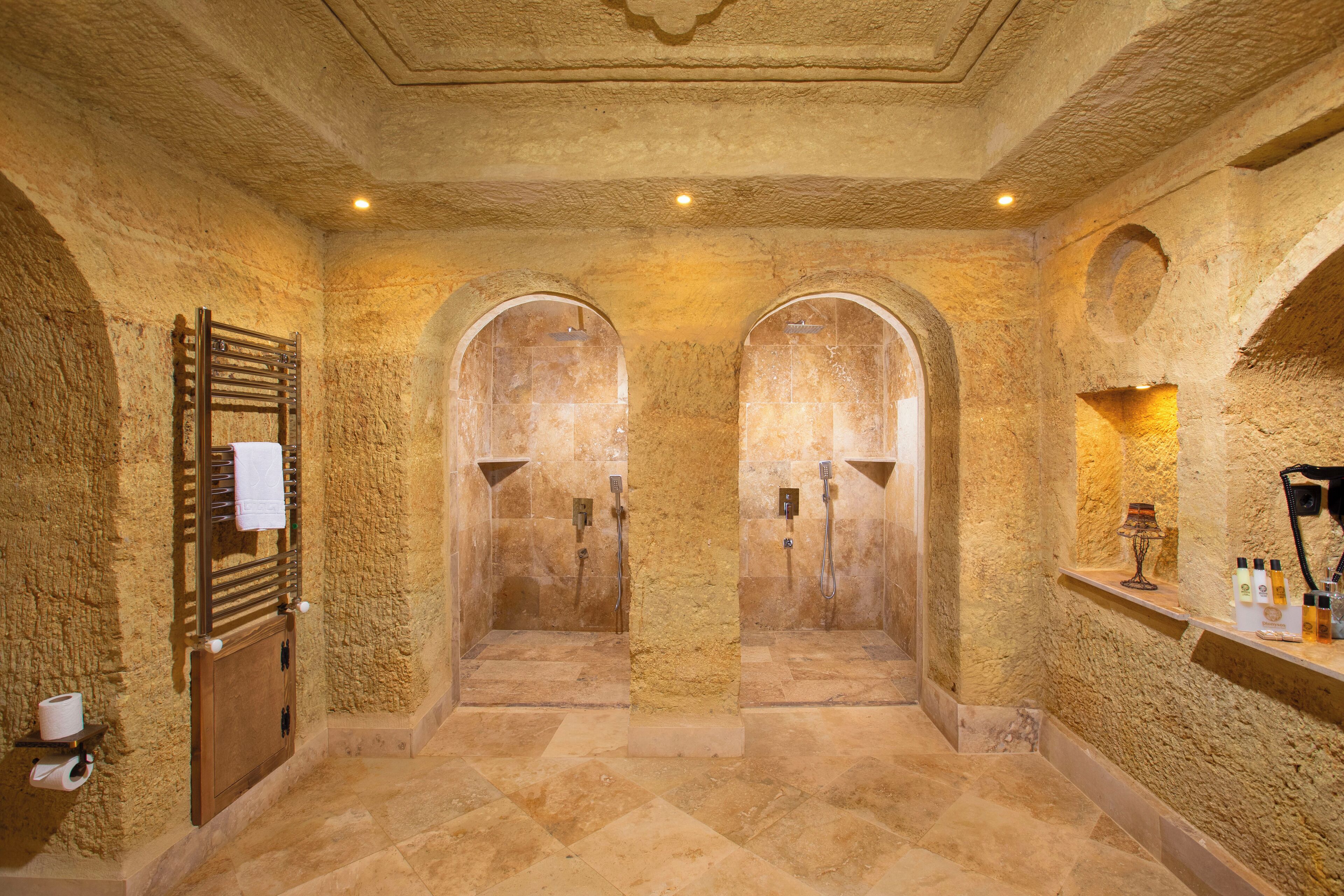Uma área de spa com duas portas em arco, um porta-toalhas e uma prateleira com artigos de higiene pessoal.