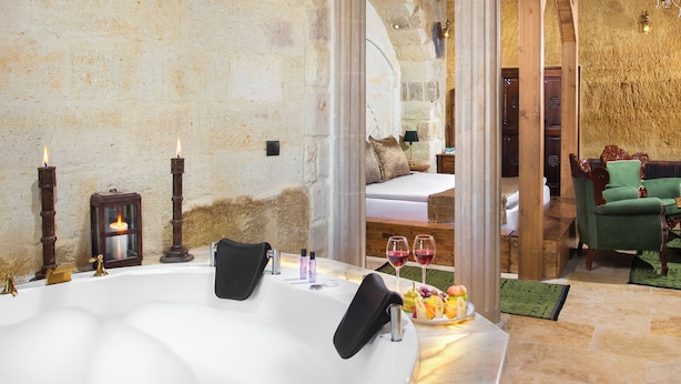 Un cuarto de spa con una bañera grande, velas y un frutero.