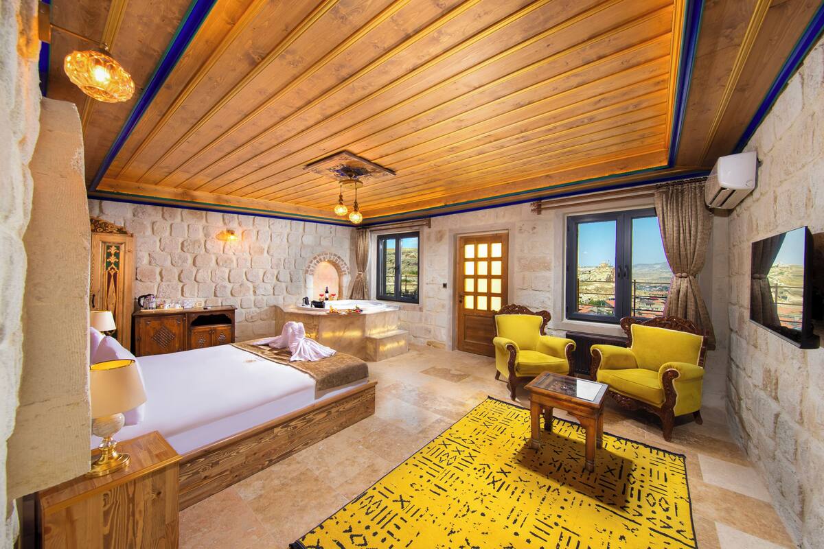 Una habitación con cama, sofá, mesa y vistas al exterior.