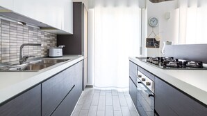A modern kitchen with a sink, stove, and cabinets. - MIA - Modern Flat Close Airport and Center (Napoli)