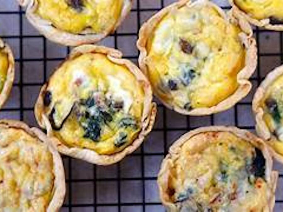 A grid of quiches on a cooling rack.