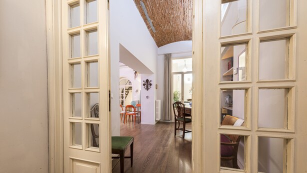 An open door leading to a dining area with wooden flooring, a green table, and several chairs. - Florence Hideaway by Mmega (Florence)