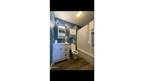 A bathroom with a white vanity, a toilet, and a shower curtain. - Mountain View 2BR Condo - No Cleaning Fee - Close to Downtown (Gatlinburg)