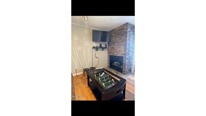 A room with a foosball table, a stone fireplace, and a wall with a dandelion design. - Mountain View 2BR Condo - No Cleaning Fee - Close to Downtown (Gatlinburg)