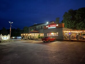 A building with a sign reading "EL BARRIL" at night.