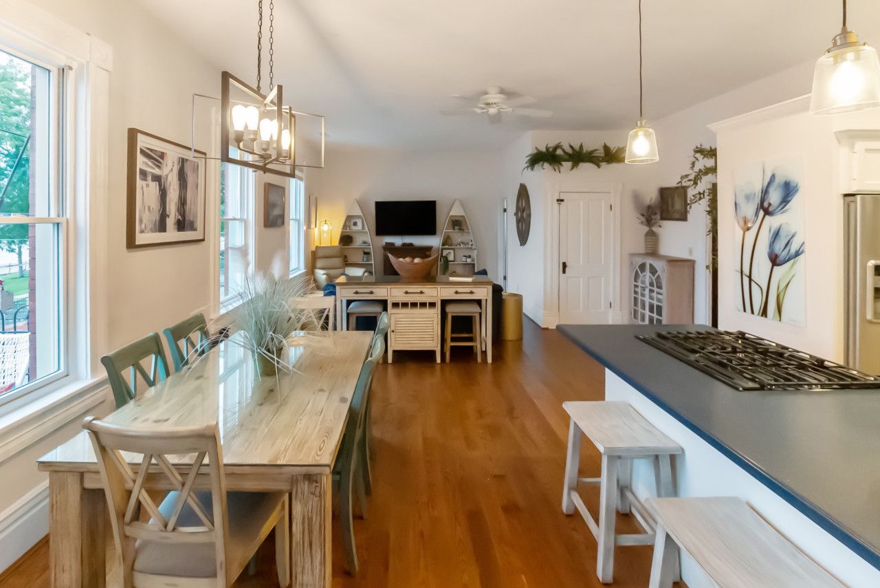 Una cocina moderna con una isla central, una mesa de comedor de madera y sillas.